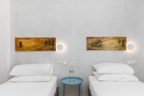 two beds in a room with two paintings on the wall at Zefyros Sea View Hotel in Platamonas