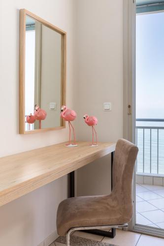 a pink flamingo figurine on a desk in front of a mirror at Zefyros Sea View Hotel in Platamonas