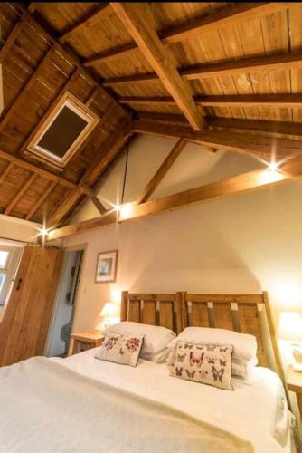 a bedroom with a bed with white sheets and pillows at Haytor Rocks, Dartmoor escape in Bovey Tracey
