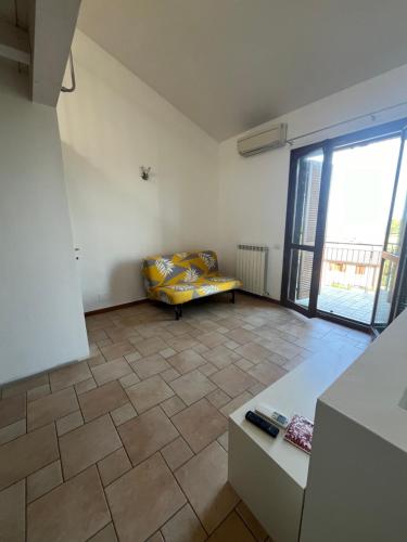 ein Wohnzimmer mit einem Sofa und einem großen Fenster in der Unterkunft Terrazza Gallo in San Costanzo