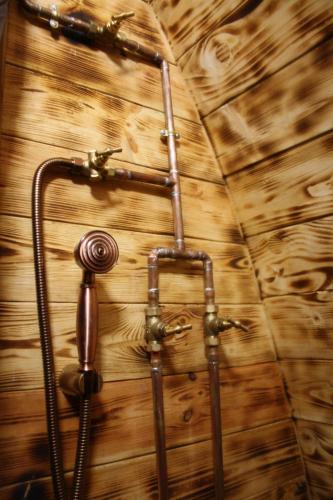 drewniany mur z prysznicem i wężem w obiekcie Lodges des Grands Chênes w mieście Andelarrot