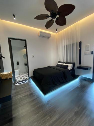 a bedroom with a black bed with a ceiling fan at Nhật Quang House 2 in Danang
