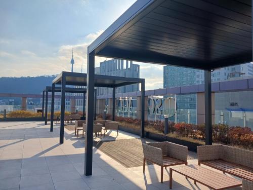 a rooftop patio with benches and tables on a building at INN-The City MyeongDong in Seoul
