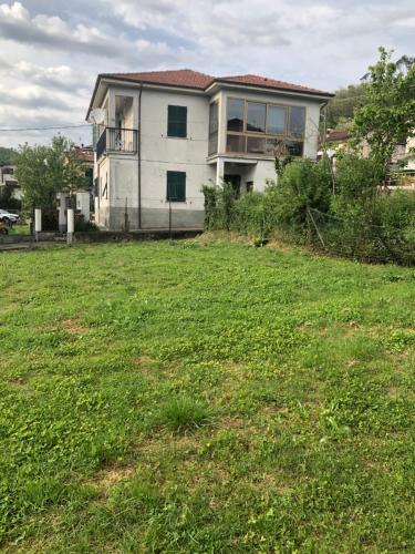a house on a hill with a green field at La Primula Vicinanza 5 Terre in Riccò del Golfo di Spezia