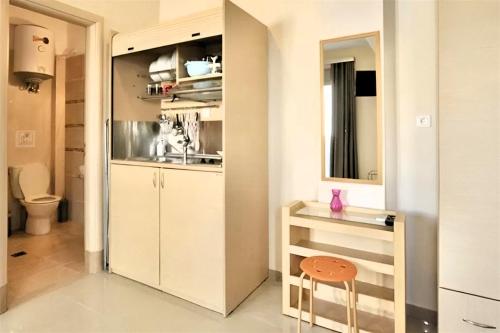 a kitchen with white cabinets and a stool in a room at GREEK PRIDE PANTHEA STUDIOS in Skala Fourkas