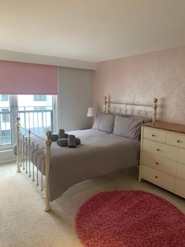 1 dormitorio con 1 cama, vestidor y ventana en Merchant City Luxury 2 Bedroom Apartment with Secure Parking Available on Request, en Glasgow