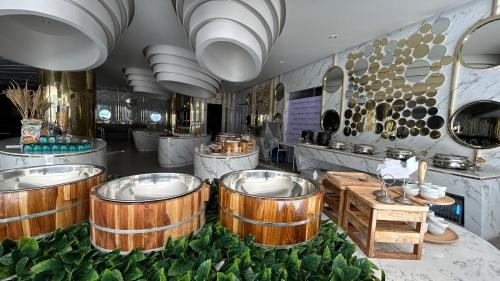 ein Restaurant mit Holzfässern auf einem Tisch mit Salat in der Unterkunft La Vita Phuket Rawai in Rawai Beach