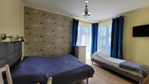 a bedroom with a bed and a window with blue curtains at Amber in Mrzeżyno