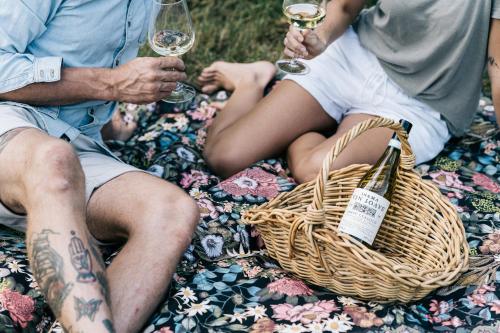 a group of people sitting on a blanket holding wine glasses at Heartwood Farm Byron Bay Luxury Farm Stay in Federal