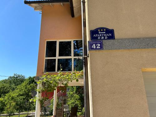 a house with a blue sign on the side of it at Apartman D&D in Jajce