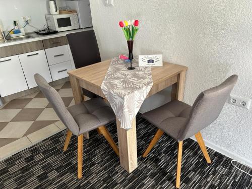 uma mesa com duas cadeiras e um vaso de flores sobre ela em Apartman D&D em Jajce