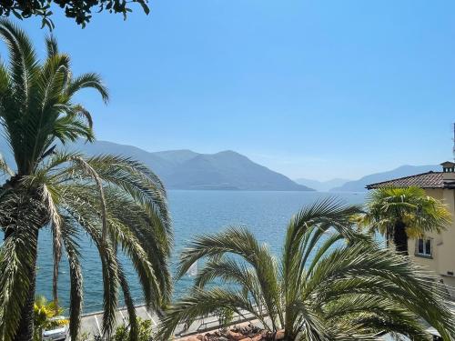 a view of the ocean and palm trees at Residenza Bettina BnB & Ferienwohnungen in Ronco s/Ascona - Porto Ronco