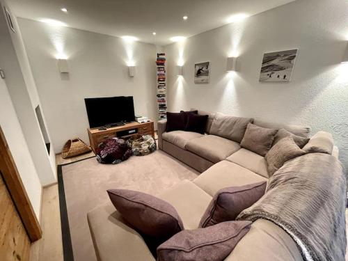 a living room with a couch and a television at Spacious Family Apt Flims close to Lake Cauma in Flims