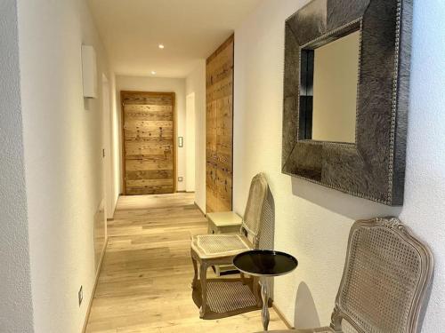a hallway with a table and chairs and a mirror at Spacious Family Apt Flims close to Lake Cauma in Flims