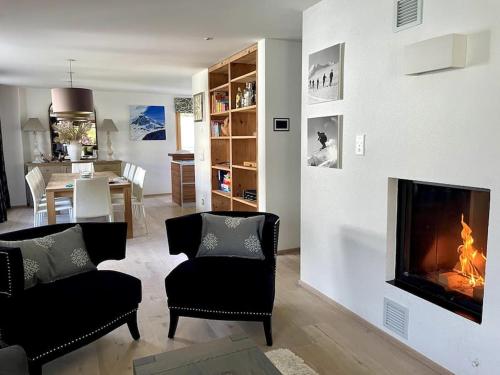 ein Wohnzimmer mit Kamin und ein Esszimmer in der Unterkunft Spacious Family Apt Flims close to Lake Cauma in Flims