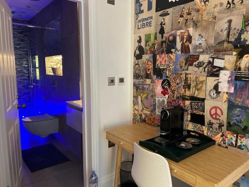 a room with a desk and a wall covered in stickers at Pop Art Luxury Room Marylebone in London