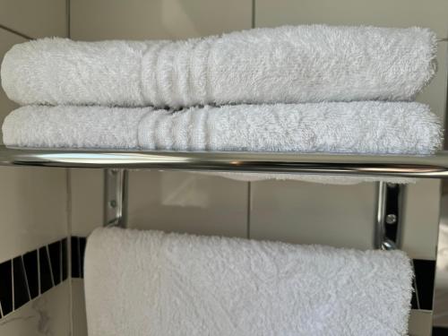 a stack of towels on a towel rack in a bathroom at Hi-Life Villa in Gaborone