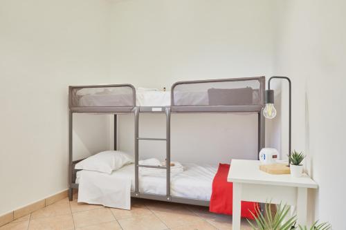 Etagenbett in einem Zimmer mit einem Tisch in der Unterkunft Villa Belveder - Piscina esclusiva, Parco e Panorama in Castelraimondo