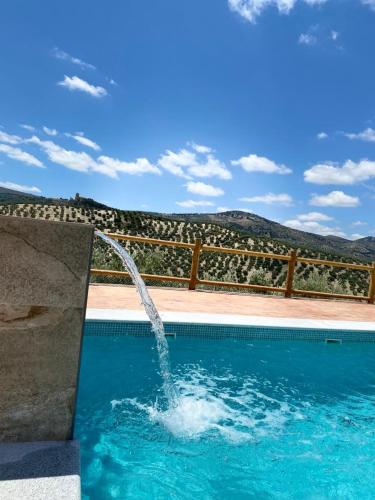 a pool with a water fountain in the middle at El Bujeo Montefrio in Montefrío