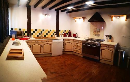une grande cuisine avec des armoires en bois et une cuisinière dans l'établissement L'Olive, à Saint-Bazile