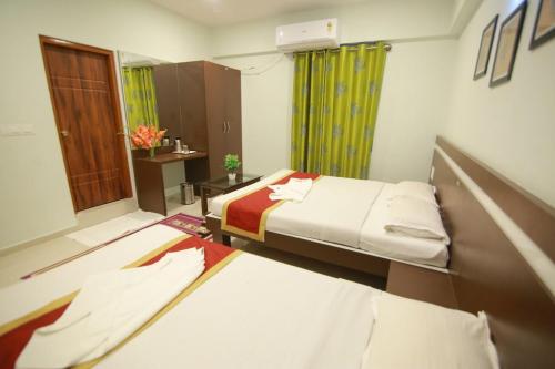 a hospital room with two beds and a window at golden residency Mysore in Mysore