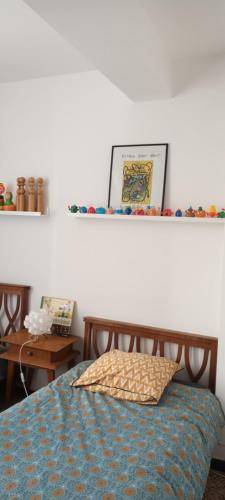 - une chambre avec un lit et une étagère sur le mur dans l'établissement Le Nid de Jeanne, à Lézignan-Corbières