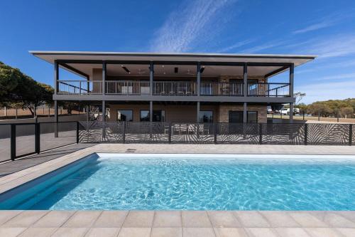 a house with a swimming pool in front of a building at The Lux Country Retreat - large swimming pool - immaculate views and stylish comfort! in Port Lincoln
