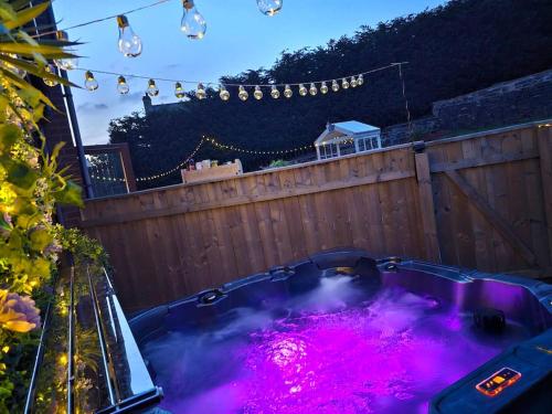 einen Whirlpool mit rosa Lichtern im Hinterhof in der Unterkunft The Chase, Luxury Hot Tub Retreat, Pets Welcomed in Dipton
