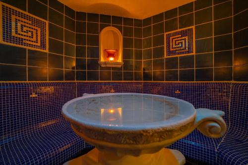 een badkamer met een bad met kaarsen bij Kontakt Wellness Hotel in Stará Lesná