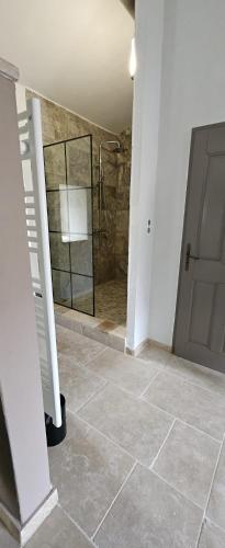 une salle de bain avec douche et porte vitrée dans l'établissement maison O jasmin, à Lagnes