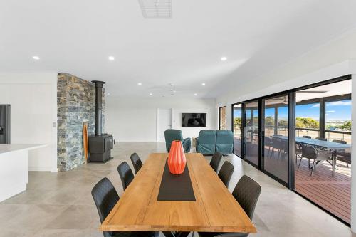 a dining room with a wooden table and chairs at The Lux Country Retreat - large swimming pool - immaculate views and stylish comfort! in Port Lincoln