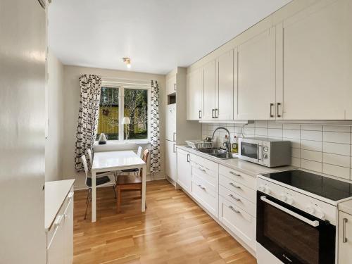 a kitchen with white cabinets and a table in it at Accommodation For Construction Workers, Växjö Area 