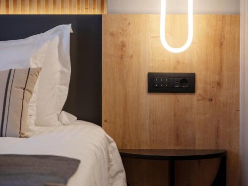 a bedroom with a bed and a light on the wall at Space Row Design Living in Heraklio Town