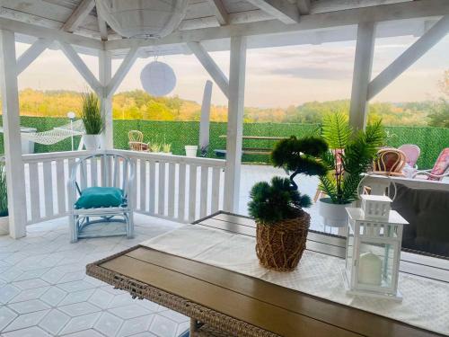 a screened in porch with a bench and potted plants at Vila Sanja in Valjevo