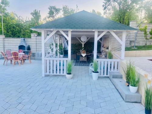 a white gazebo with a table and chairs at Vila Sanja in Valjevo