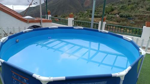 una piscina azul en la azotea de una casa en Encantadora Casa cueva en Valsequillo en Las Palmas de Gran Canaria