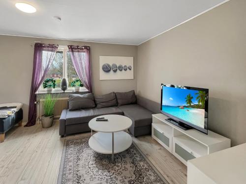 a living room with a couch and a flat screen tv at Coparate Housing - Equipped Apartments For Work Crews in Bergdala