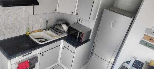 a small kitchen with a sink and a refrigerator at Chambre dans Appartement - Grenoble, France à 8 min du centre-ville in Grenoble