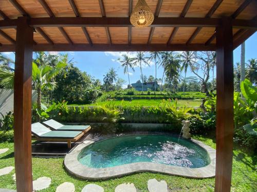 a swimming pool in a garden with a pergola at Arvanya Villa Ubud in Tegalalang