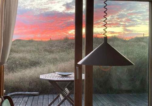 a view of a sunset from a porch with a table at Scenic Holiday Home In Skagen, in Skagen