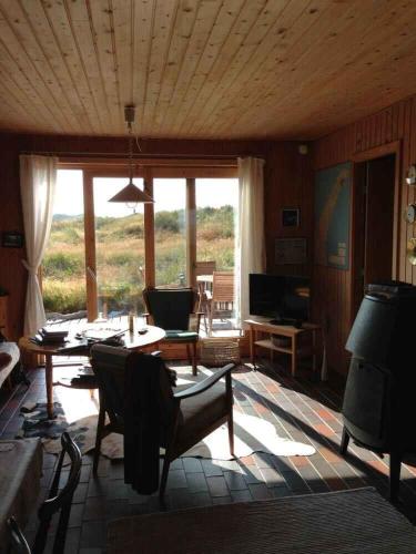a living room with a table and chairs and a couch at Scenic Holiday Home In Skagen, in Skagen