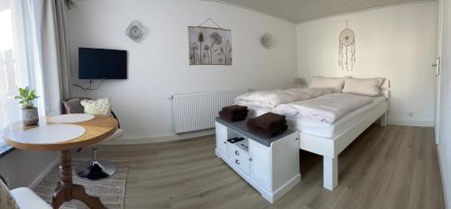 a bedroom with a bed and a table and a desk at Ferienwohnung am Waldrand in Tharandt