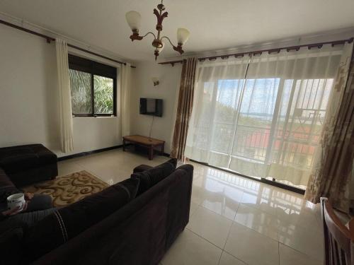 - un salon avec un canapé et une grande fenêtre dans l'établissement HA LUXURY Air b&b, à Kampala