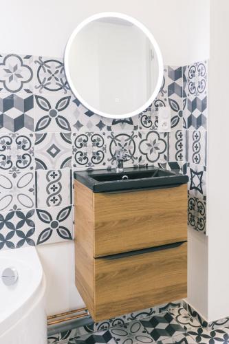 une salle de bain avec un lavabo et un miroir dans l'établissement L'original, à Joigny
