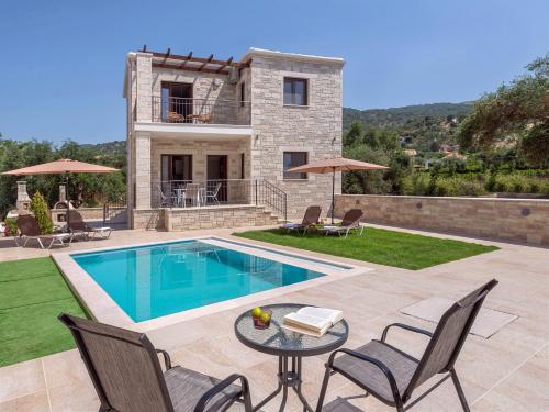 a villa with a swimming pool and a house at Tesoro luxury apartments in Sivota