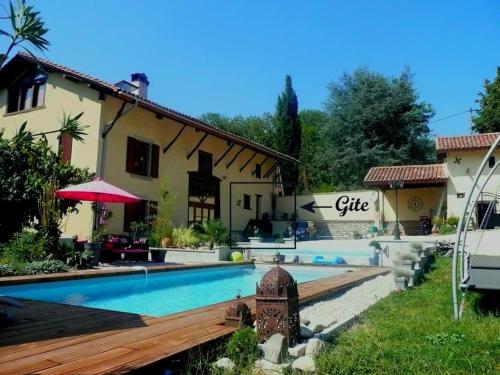 eine Villa mit einem Pool vor einem Haus in der Unterkunft Gîte Le Clos d'Olon 4 étoiles avec piscine in Charnècles