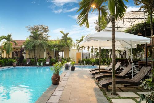 寧平的住宿－Dong Ne Tam Coc Hotel & Resort，一个带椅子和遮阳伞的游泳池