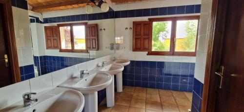 a bathroom with three sinks and two windows at Albergue Laganares 