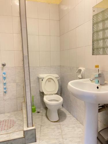 a bathroom with a toilet and a sink at Sunrise Resort 1BR Apartment in Nyali