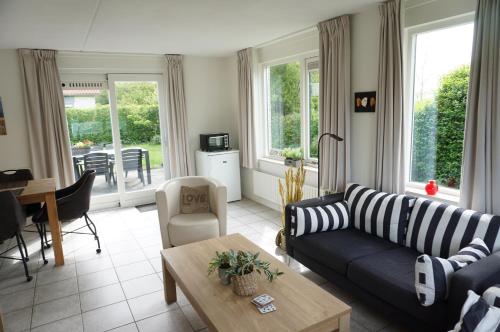 a living room with a couch and a table at Kustverhuur, Park Schoneveld, Stern 240 in Breskens